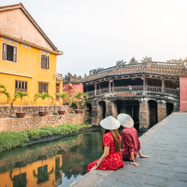Travel,couple,with,japanese,covered,bridge,,in,hoi,an,,vietnam